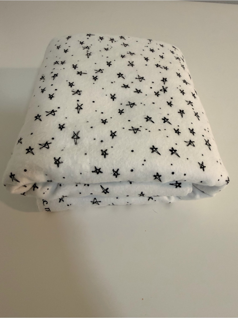 Super Snuggle white flannel fabric with black stars. 42” wide, 2 yards.